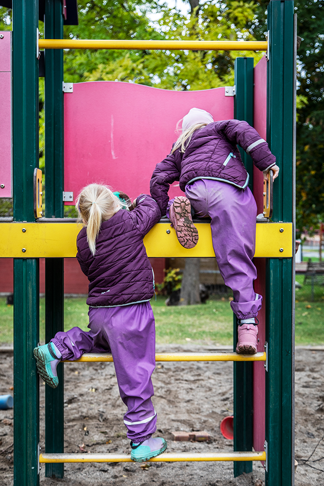 To barn som klatrer i et klatrestativ